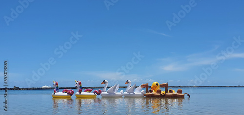 several buoys in the shape of animals by the sea on a blue sky day