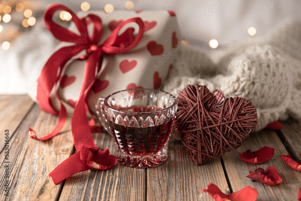 A composition for Valentine's Day with a red drink, a gift and decor details. A composition for Valentine's Day with a red drink, a gift and decor details.