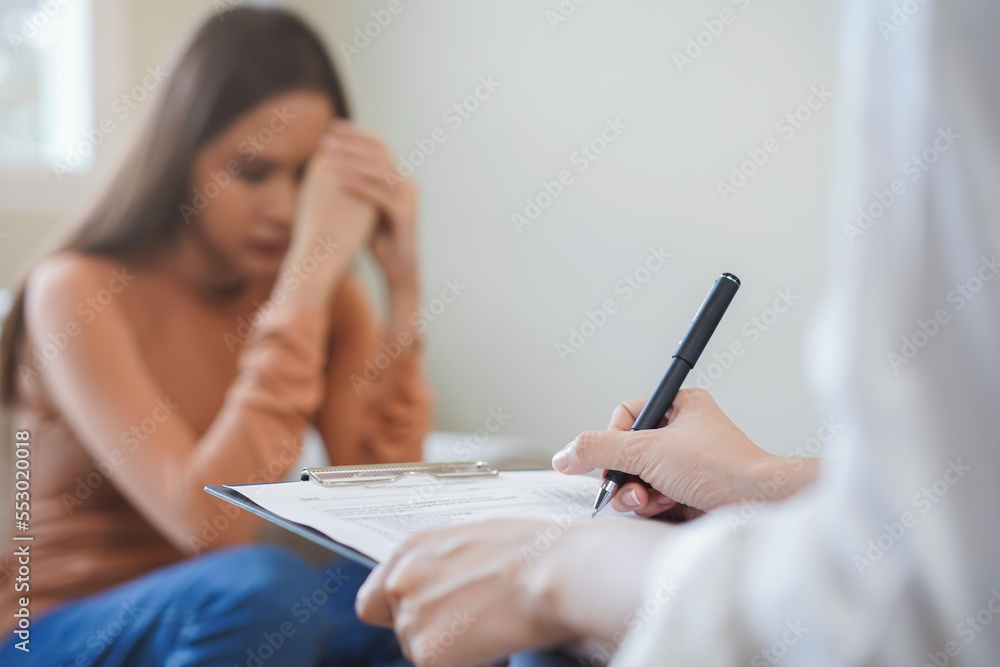 Psychology, depression. Sad, suffering asian young woman, girl consulting with psychologist, psychiatrist while patient counseling mental with doctor hand taking notes at clinic. Encouraging, therapy. Psychology, depression. Sad, suffering asian young woman, girl consulting with psychologist, psychiatrist while patient counseling mental with doctor hand taking notes at clinic. Encouraging, therapy.
