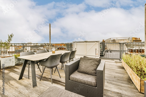 Foto a roof deck with chairs, tables and an outdoor dining area in the fore - image i