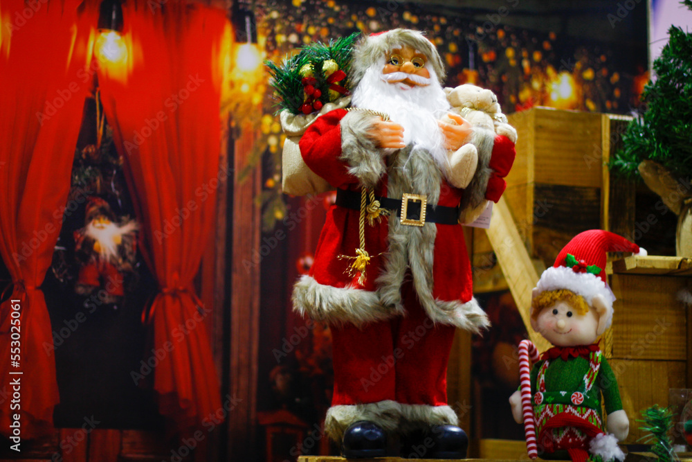 santa claus and his assistant with christmas background