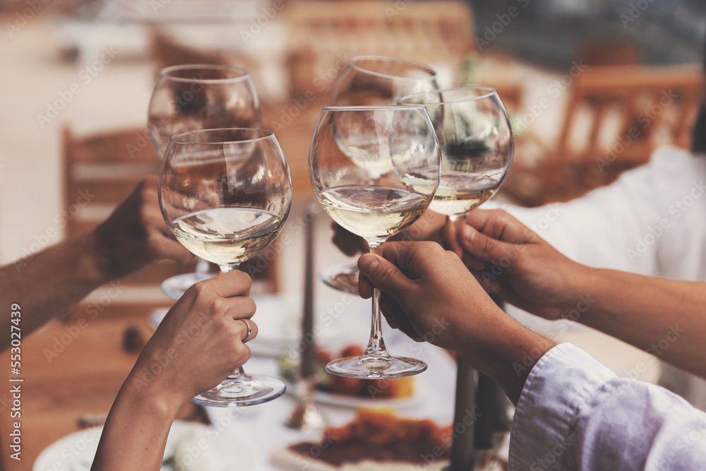 Closeup hand of friends clinking glasses of white wine, Dinner wood table warm toning