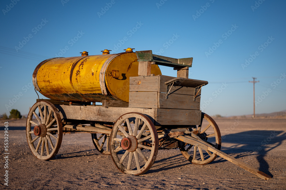 Old horse-drawn wooden cart with a yellow tank