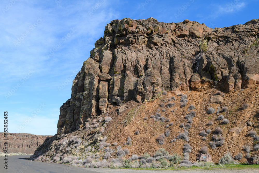 Fototapeta premium Basalt cliff at Frenchman Coulee rising above historic Highway 10 in Eastern Washington State