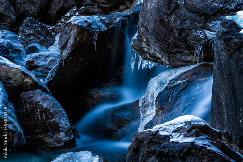 Fantastic ice formations grow in winter icy mountain stream