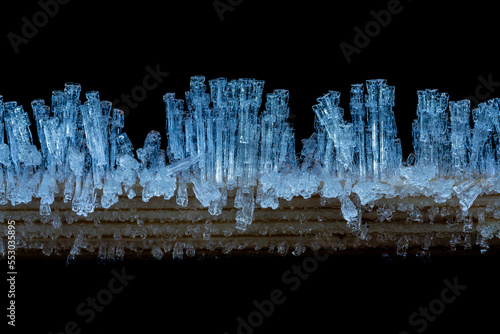 Wooden stick in winter decorated with wonderful ice crystals