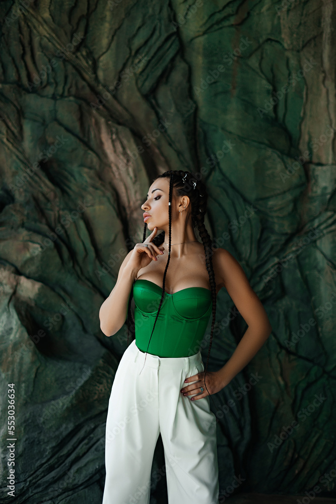 Obraz premium beautiful brunette in a green top shows off her breasts after plastic surgery
