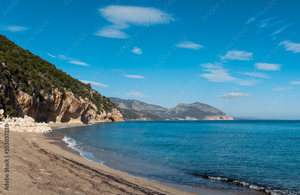 overhanging cliffs and sandy beach at Cala Luna on the east coast of Sardinia