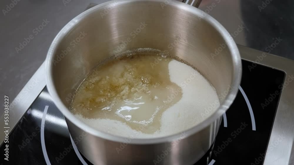 A close-up of the caramel cooking process, the caramel boils in a frying pan. Sugar melts while boiling in a saucepan. A close-up of the caramel cooking process, the caramel boils in a frying pan. Sugar melts while boiling in a saucepan.