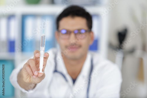 close up of doctor holding syringe with injection