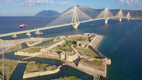 Aerial drone video of iconic medieval ancient castle of Rio built next to modern cable strait bridge of Harilaos Trikoupis crossing corinthian Gulf, Central Greece photo