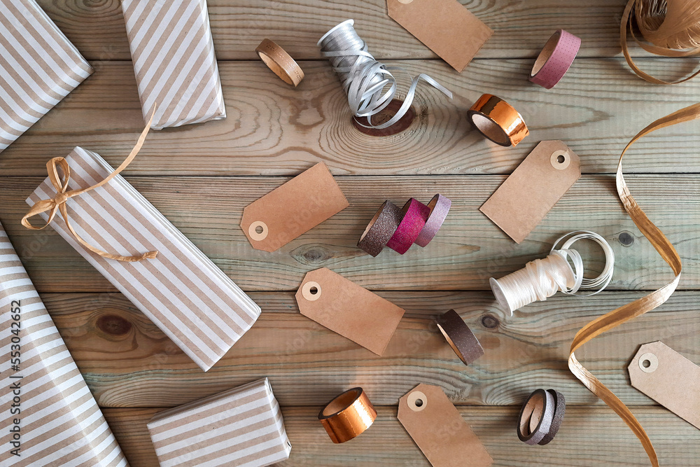 Gift wrapping set. Top view. Holiday preparation concept. Idea for master class. Gift boxes, tags, ribbons, threads made from natural materials on wooden table. Flat lay. DIY packaging with family Gift wrapping set. Top view. Holiday preparation concept. Idea for master class. Gift boxes, tags, ribbons, threads made from natural materials on wooden table. Flat lay. DIY packaging with family