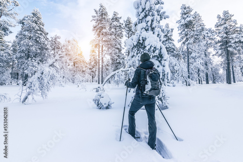 Snowshoe hiker walking in the snow. Outdoor winter sport activity and healthy lifestyle concept.
