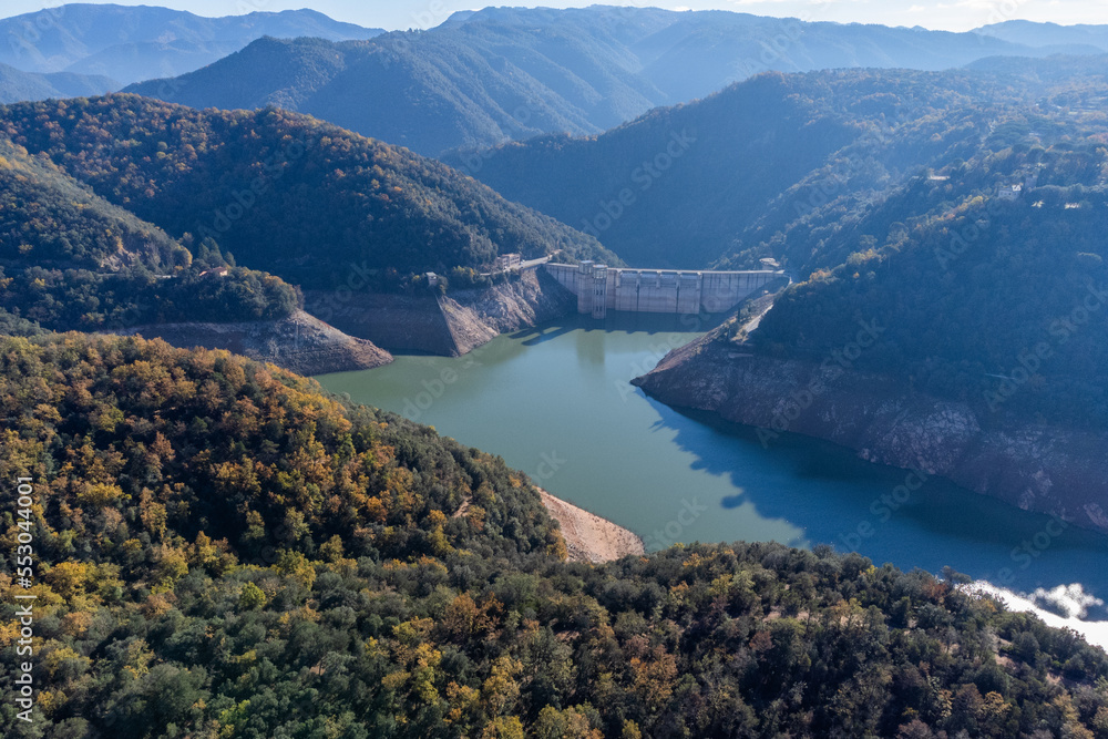 Sau reservoir dam with water levels much lower than usual due to Drought impact, water crisis, water consumption, water shortage concept. Pantà de Sau, Catalonia.