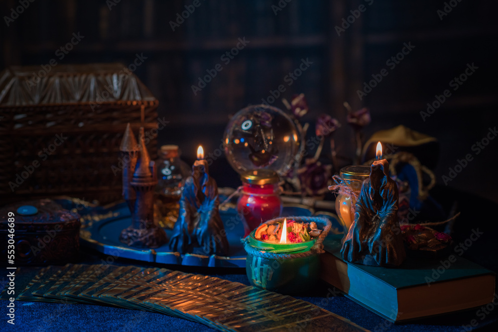 Fortune-telling cards and burning candles on a table on mystic background 