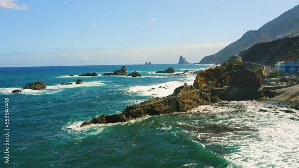 Blue ocean rocky coastline in the wild north of Tenerife. Small seaside town Taganana. Anaga beach with Roque de las Bodegas. Aerial footage of volcanic rock formation in the sea. Blue ocean rocky coastline in the wild north of Tenerife. Small seaside town Taganana. Anaga beach with Roque de las Bodegas. Aerial footage of volcanic rock formation in the sea.