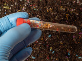 Microplastics in soil a test tube with soil sample - soil contaminated with mineral microplastics