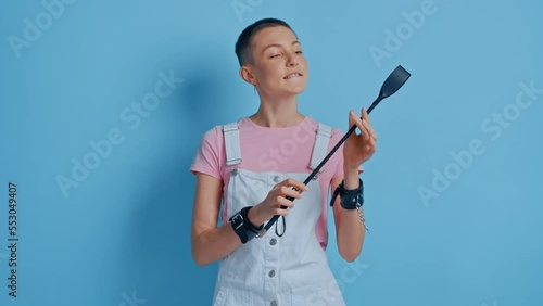 Confident bdsm woman posing with black whip and enjoying dominance at relationships photo