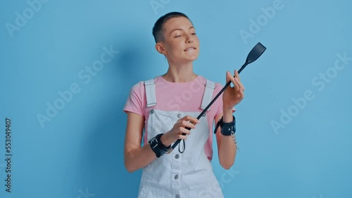 Confident bdsm woman posing with black whip and enjoying dominance at relationships