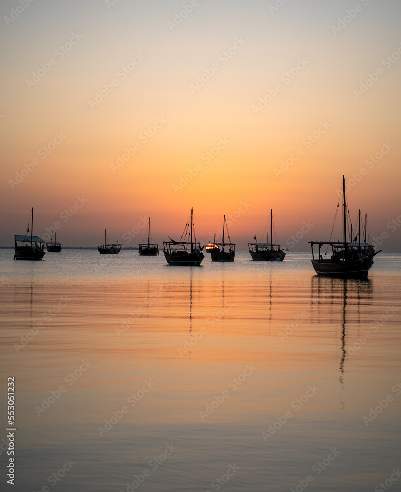 Arab traditional dhows in the shore during the sunrise in Qatar