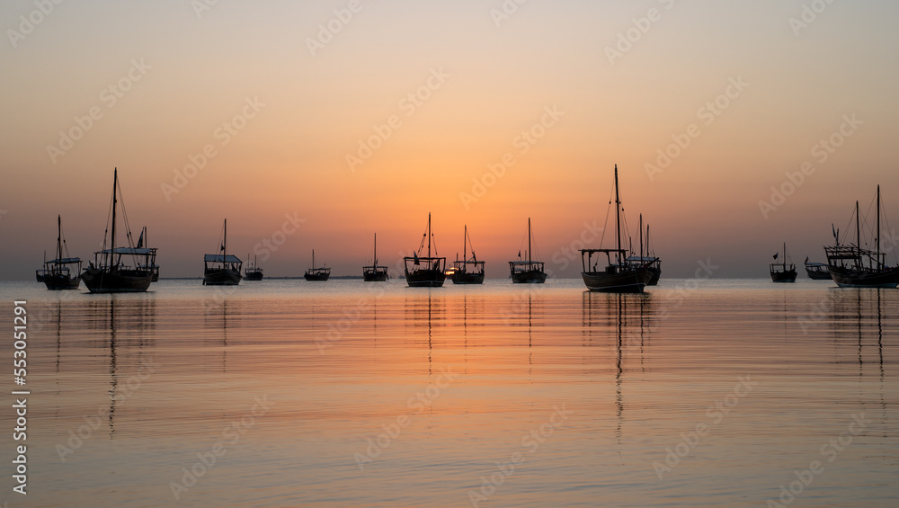 Arab traditional dhows in the shore during the sunrise in Qatar