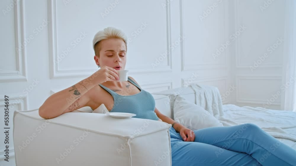 Excited woman sipping beverage enjoying a cup of coffee at home Excited woman sipping beverage enjoying a cup of coffee at home