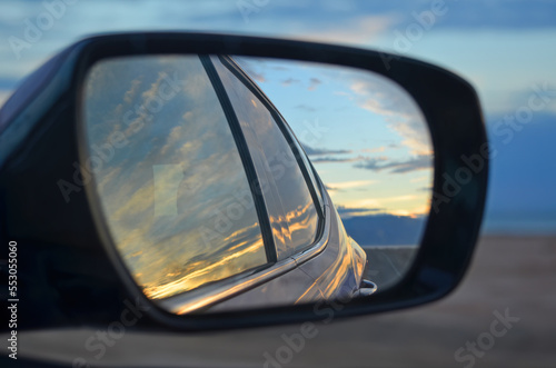 Sunset reflection in the side mirror of a car