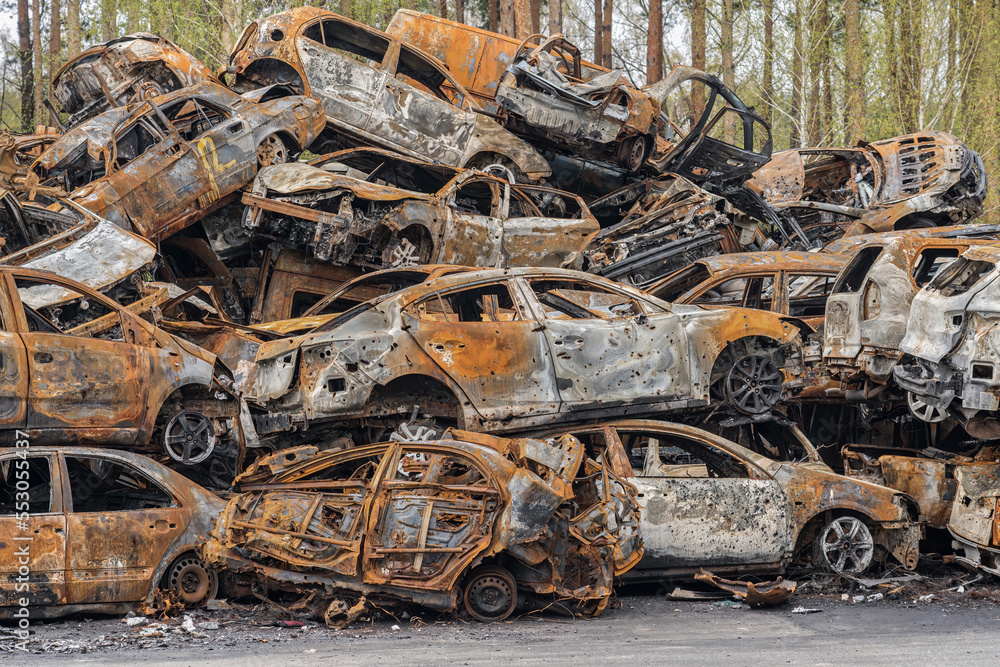 A hill of burned cars in a junkyard. Civilian cars were destroyed as a result of hostilities