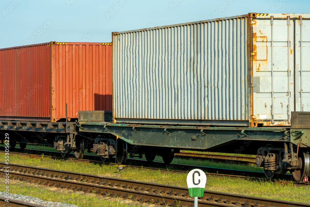 Cargo transportation by rail. There is a transport train with containers on the railway track. Logistics, transportation of essential goods, grain, fuel, industrial goods. Cargo transportation by rail. There is a transport train with containers on the railway track. Logistics, transportation of essential goods, grain, fuel, industrial goods.