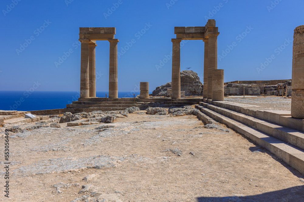 Fototapeta premium Panoramic view of ruins of ancient city of Lindos on colorful island of Rhodes, Greece. Famous tourist attraction. Ancient temple Greek architecture. High quality photo