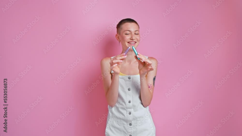 Cute woman with piercing holding two satisfiers and laughing to the camera Cute woman with piercing holding two satisfiers and laughing to the camera