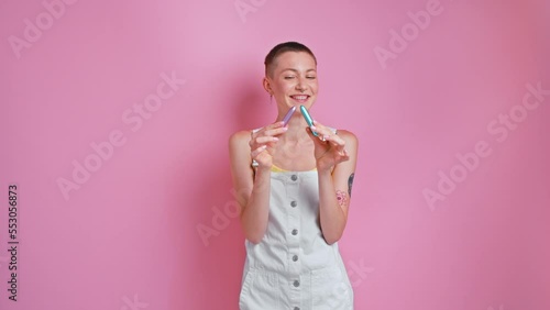 Cute woman with piercing holding two satisfiers and laughing to the camera photo