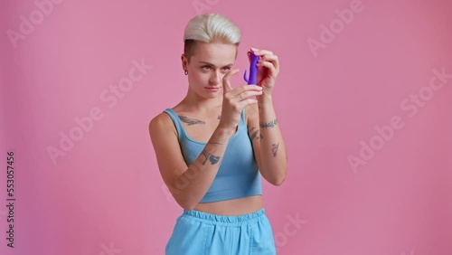 Short haired woman posing to the camera with violet vibrator for clitoral vaginal stimulation photo