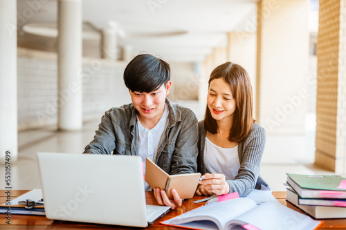 Two students are sitting at table reading books to education. Study for test preparation in University.Education, Learning, Student, Campus, University, Lifestyle concept.
