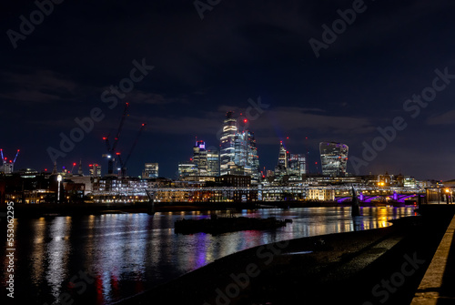Beautiful view of London city landscape from Thames waterfront at night  handheld shot. Rapid growth and urban development concept.