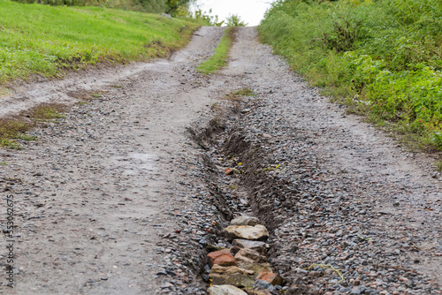 Washed out dirt road on hillside with scour after rain