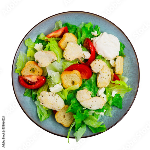 Portion of fresh Caesar salad with tomatoes served on plate in restaurant. Isolated over white background