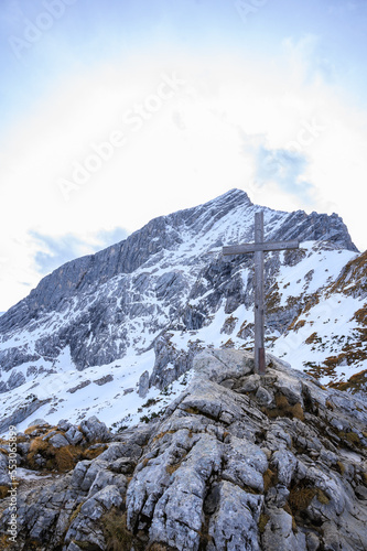 Holzkreuz auf einem Gipfel in den bayrischen schneebedeckten Alpen im Winter