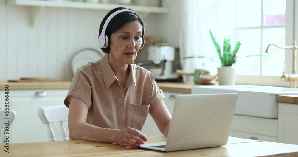 Mature tutor wear wireless headphones leads on-line class to learners using laptop and videoconference application, working from home, get or provide professional electronic services. Virtual meeting Mature tutor wear wireless headphones leads on-line class to learners using laptop and videoconference application, working from home, get or provide professional electronic services. Virtual meeting
