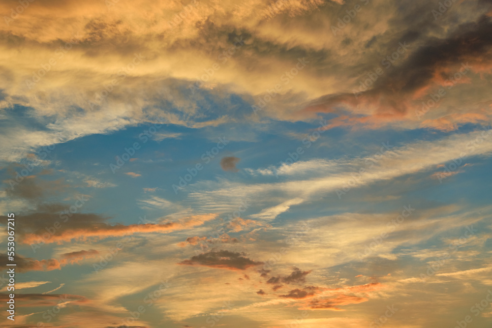 Pastel clouded sky on the sunset in yellow, orange and blue colors