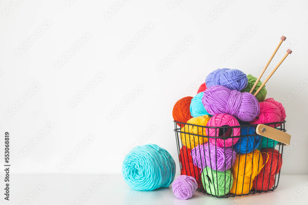 Cozy homely atmosphere. Female hobby knitting and Crochet. Yarn multicolor  in a basket. Skeins and balls. Stock Photo