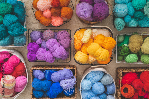 Many baskets made of natural eco-friendly materials. Multicolor yarn for knitting, knitting needles and scissors. Home storage concept and hobby handmade.