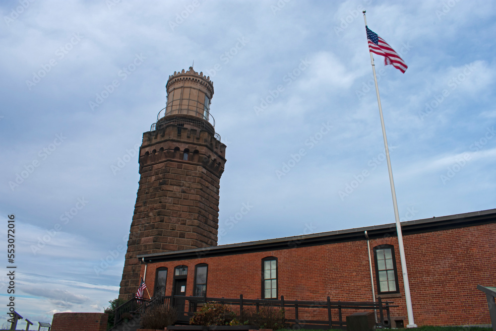 United States flag waving in the breeze next to the north tower of the historic Navesink Twin Lighthouses in Highlands, New Jersey, USA -11