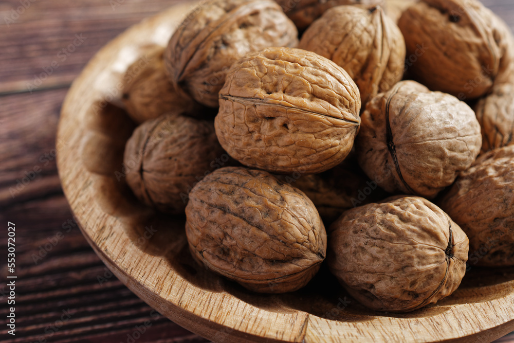 Close up of walnuts in a wooden bowl. Close up of walnuts in a wooden bowl.