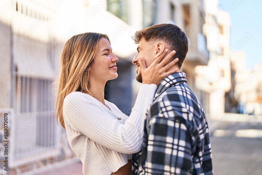 Young man and woman couple hugging each other standing at street Young man and woman couple hugging each other standing at street