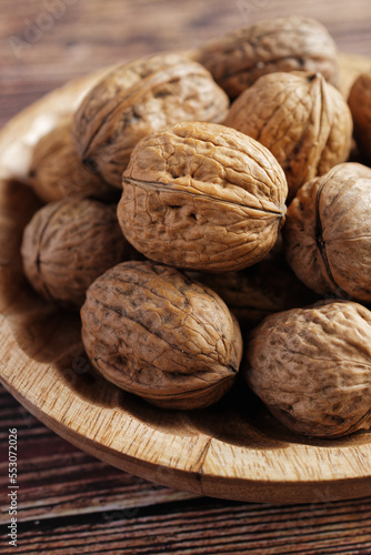 Close up of walnuts in a wooden bowl.