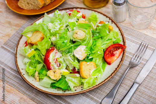 Popular dish of american cuisine is Caesar salad, made from lettuce leaves, boiled chicken breast, tomatoes, croutons and ..seasoned with sauce