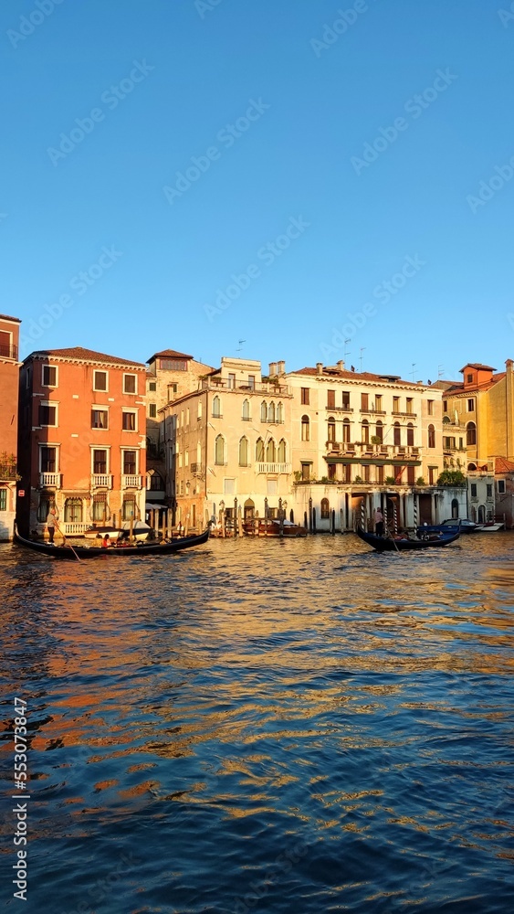 View of the Venetian Canal on a sunny day, buildings and boats. Venice, Italy