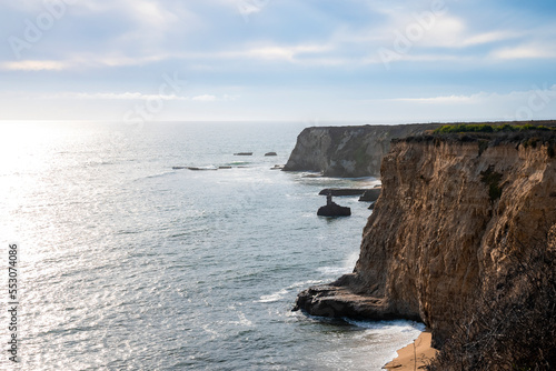 Idyllic view of cliff amidst beautiful seascape with cloudy sky in the background at Pigeon Point during sunny day