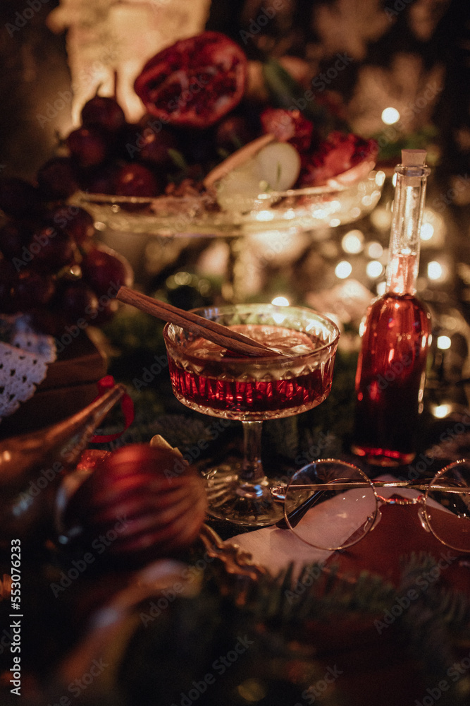 Fototapeta premium Christmas dark academia vintage harry potter table for two with fir, candles, mulled wine, red decorations, old books, glasses, gingerbread and chess